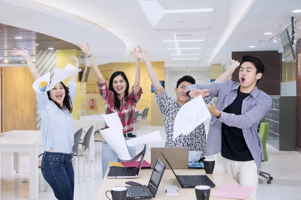 Equipe de negócios celebra o sucesso jogando papéis — Fotografia de Stock