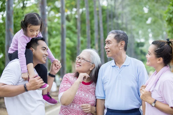 Kiterjesztett család beszél egymással a parkban — Stock Fotó