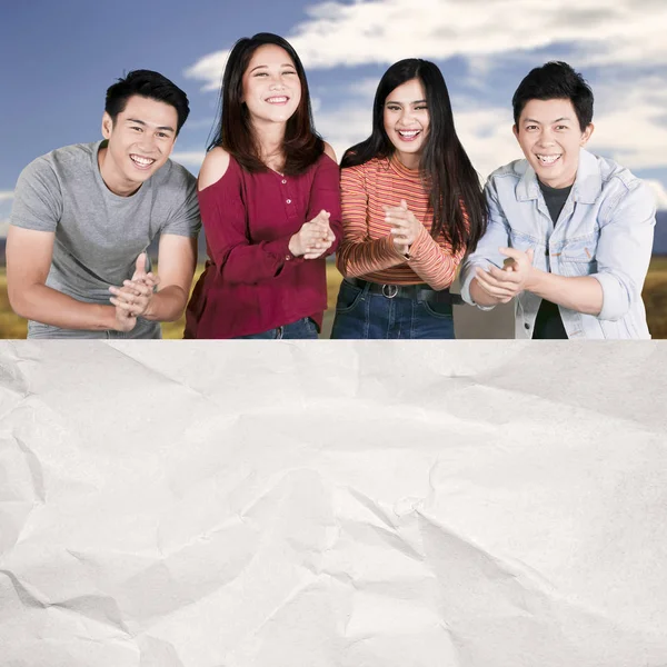 Happy College studenter applåderar nära ett tomt papper — Stockfoto