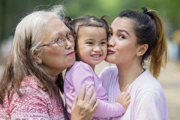 Ευτυχισμένο μικρό κορίτσι φιλούσε από τη μητέρα και τη γιαγιά της — Φωτογραφία Αρχείου