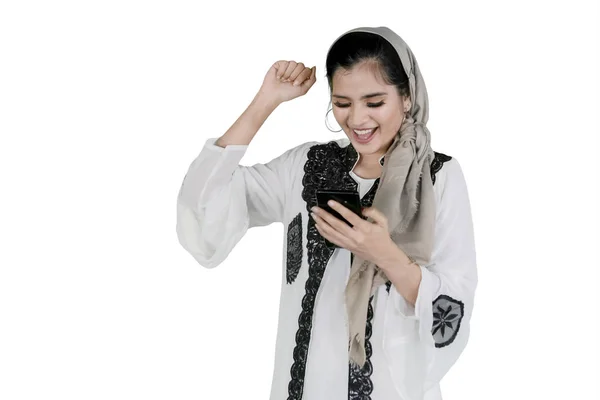 Glückliche Muslimin mit Smartphone im Studio — Stockfoto