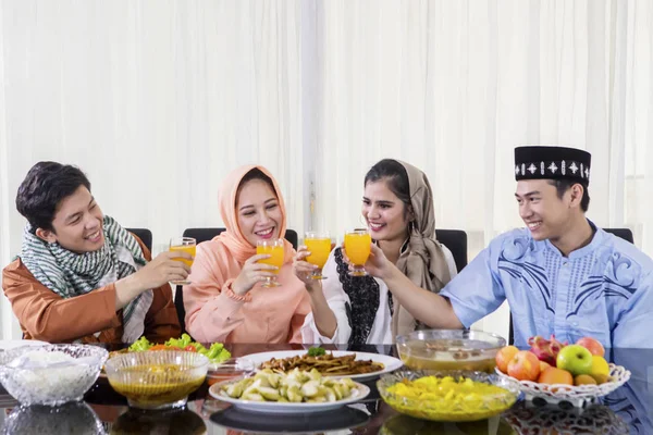 Glückliche Menschen stoßen an, bevor sie gemeinsam das Fasten brechen — Stockfoto