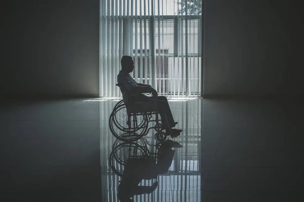 Hombre viejo solitario se ve triste en la silla de ruedas — Foto de Stock