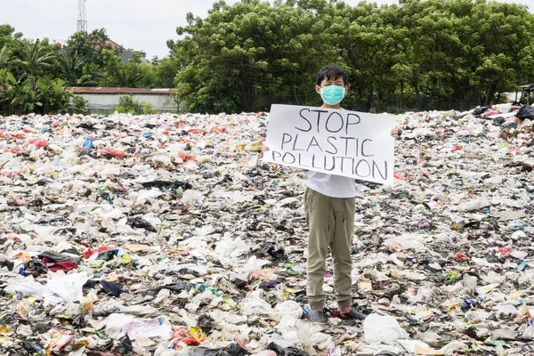 Male teenager holds stop plastic pollution text