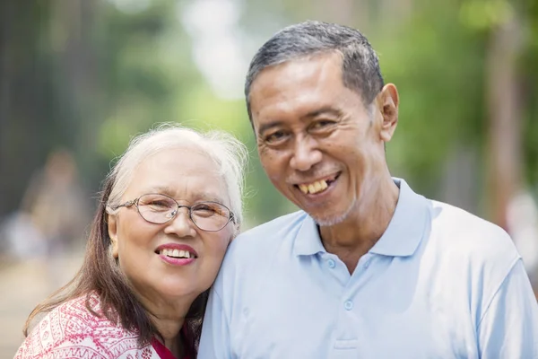 Asiático viejo pareja sonriendo a la cámara — Foto de Stock