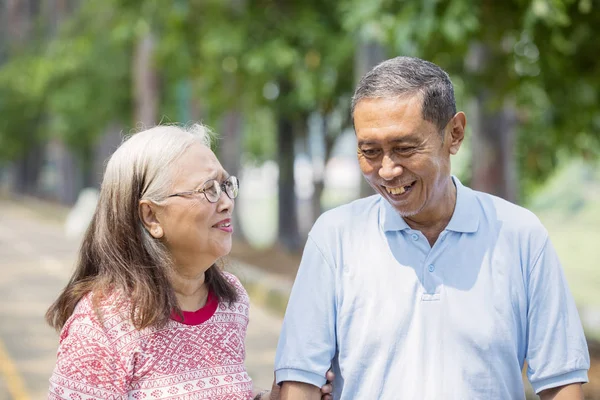 Happy aged couple chatting in the park — Stock Photo, Image