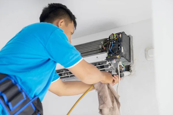 Техник-мужчина чистит охладитель катушек кондиционера — стоковое фото
