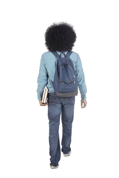 Vista posteriore di Afro studente universitario passeggiate in studio — Foto Stock