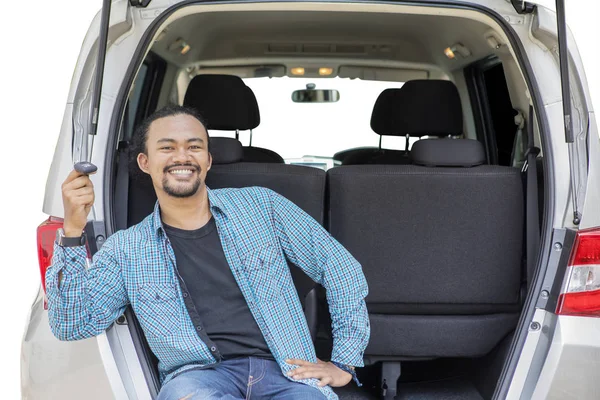 Gülümseyen Afro adam araba bagajında yeni bir araba anahtarı tutar — Stok fotoğraf