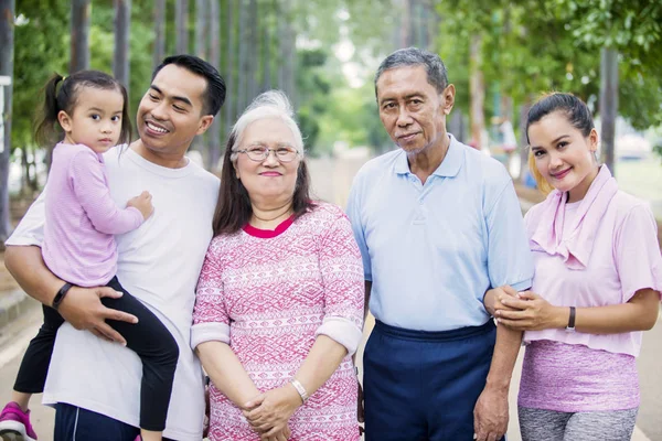 Keluarga tiga generasi tersenyum melihat ke kamera — Stok Foto