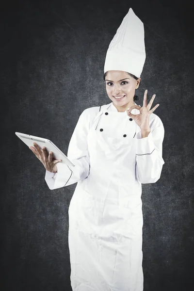 Ženská šéfkuchařka zobrazující nápis ok ve studiu — Stock fotografie