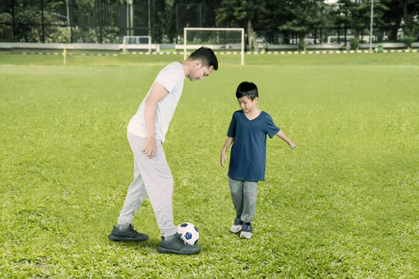 Pappa spelar fotboll med sin son på fältet — Stockfoto