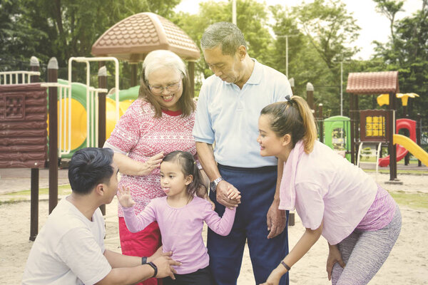 Little child plays with her family in the playground