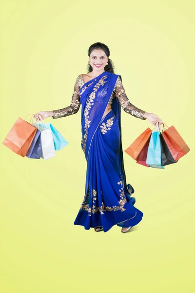 Pretty Indian girl carries shopping bags on studio — Stock Photo, Image