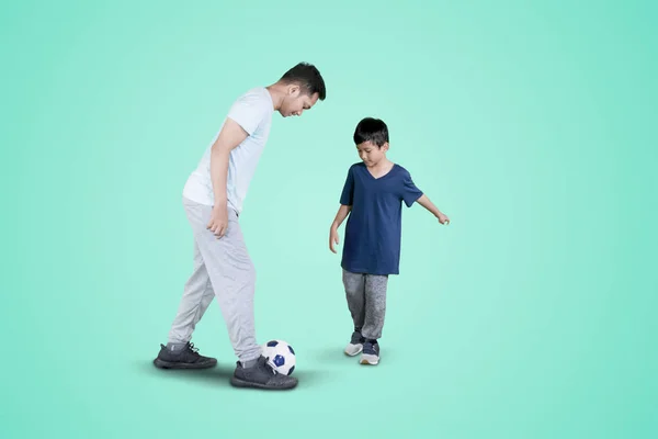 年轻人和他的儿子做足球运动 — 图库照片