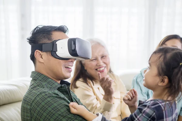 Hombre joven con auriculares VR con su familia —  Fotos de Stock
