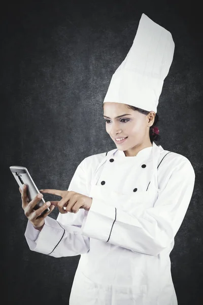 Hermosa chef femenina usando un teléfono móvil — Foto de Stock