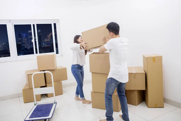 Casal segurando uma caixa de papelão no novo apartamento — Fotografia de Stock