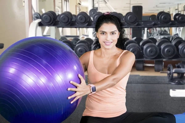 Cabello rizado mujer sostiene una pelota en el gimnasio — Foto de Stock