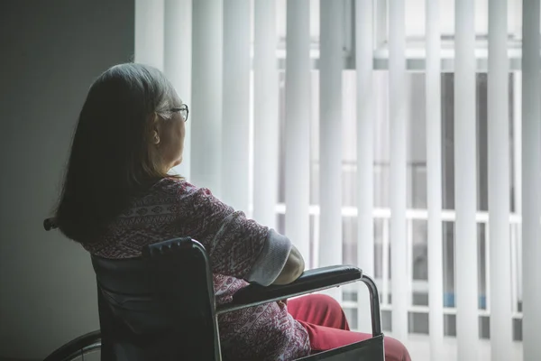 Disabili vecchia donna guardando fuori dalla finestra — Foto Stock