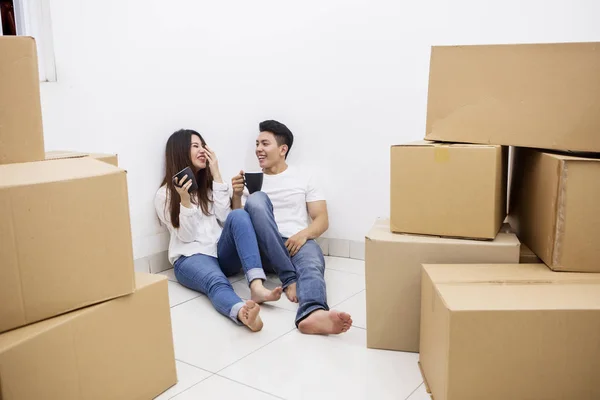 Casal feliz bebe café quente na nova casa — Fotografia de Stock