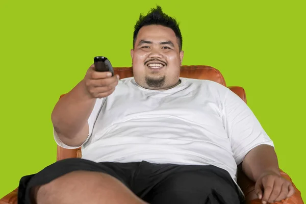 Happy fat man watching television on studio — Stock Photo, Image