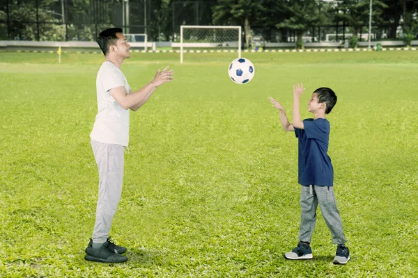 快乐的小男孩把球扔给他的父亲 — 图库照片