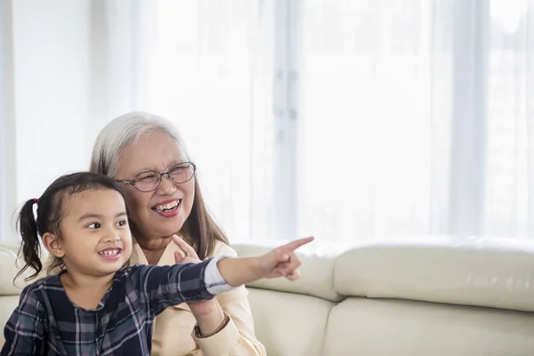 Glückliches kleines Mädchen vor dem Fernseher mit ihrer Großmutter — Stockfoto