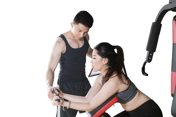 Man helps his client to train with a machine exercise — Stock Photo, Image