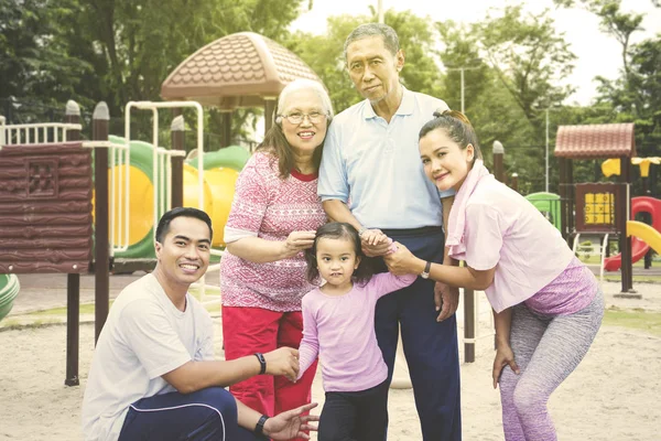 Família de várias gerações sorrindo no playground — Fotografia de Stock