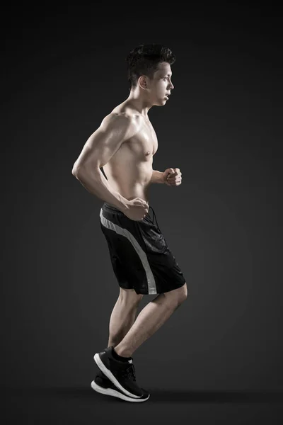 Muscled young man doing run exercises — Stock Photo, Image