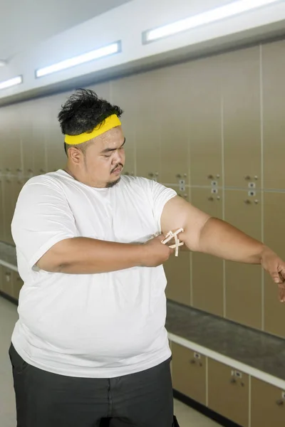 Obese man measures fat layer of his arm — Stock Photo, Image