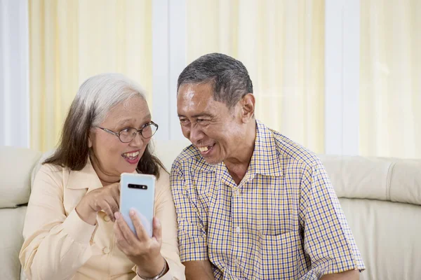 Vieux couple faisant un appel vidéo à la maison — Photo