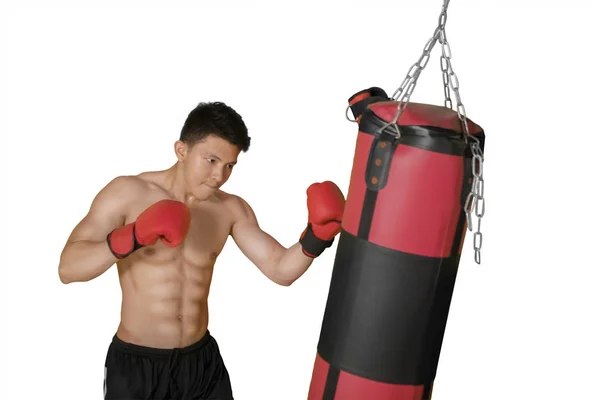 Un hombre sin camisa golpeando una bolsa de boxeo — Foto de Stock