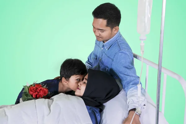 Malade jeune femme embrassée par son fils en studio — Photo