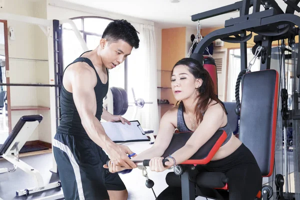 Trainer guides his client to train in the gym center — Stock Photo, Image