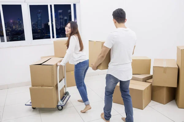 Pareja joven lleva cajas a su nuevo apartamento — Foto de Stock