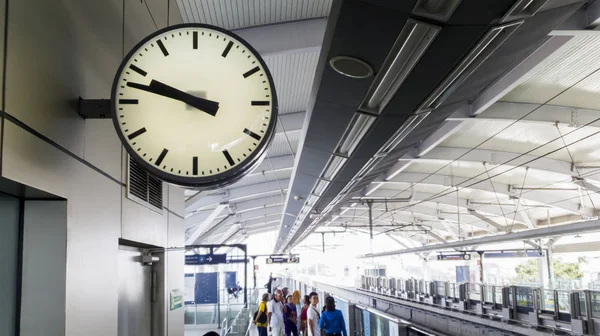 Uhr mit überfüllten Fahrgästen am Bahnhof — Stockfoto