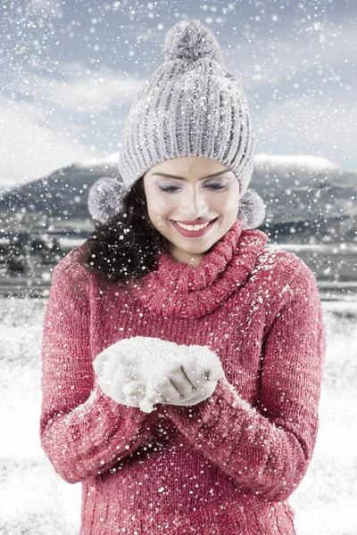 Femme heureuse tenant la neige sur ses paumes — Photo