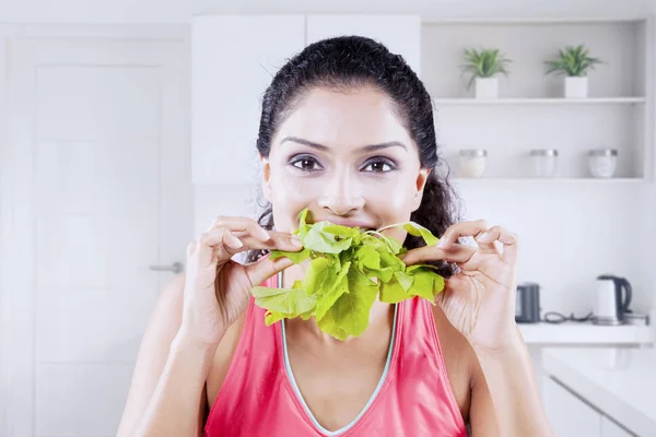 Mujer joven feliz comiendo espinacas frescas crudas —  Fotos de Stock