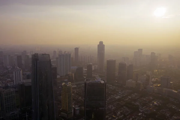 Paisagem urbana de Jacarta coberta pela poluição atmosférica ao amanhecer — Fotografia de Stock