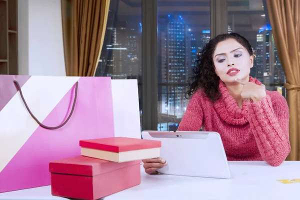 Nachdenkliche Frau kauft online in der Wohnung ein — Stockfoto