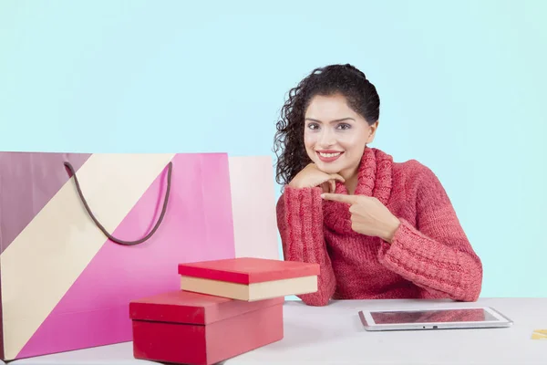 Lächelnde Frau zeigt Einkaufstüten auf Atelier — Stockfoto