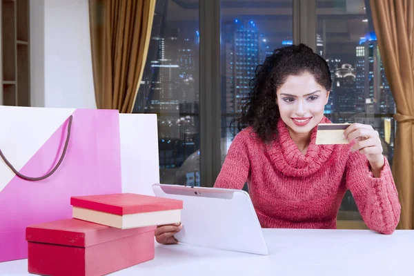 Mujer sonriente usando una tarjeta de crédito y una tableta — Foto de Stock