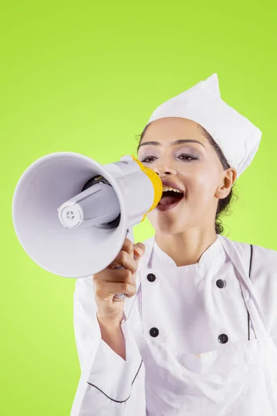 Jonge vrouwelijke chef-kok met behulp van een megafoon op Studio — Stockfoto