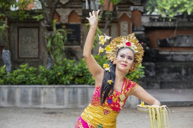 Bali dansçı çiçek yaprakları bir kase ile dans