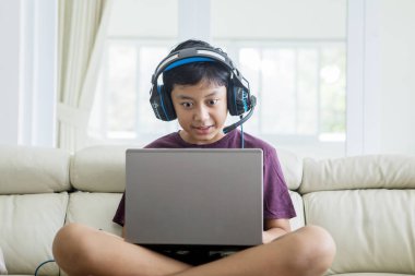 Asya preteen çocuk dizüstü bilgisayarda online oyun oynuyor