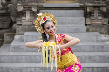 Bali dansçı çiçek yaprakları bir kase ile dans