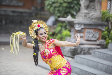 Bali dansçı çiçek yaprakları bir kase ile dans