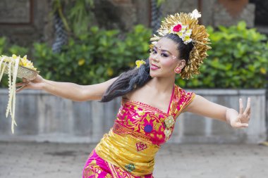Bali dansçı çiçek yaprakları bir kase ile dans